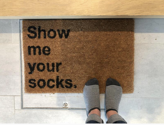 Paillasson « Show me your socks » à l'entrée du cabinet